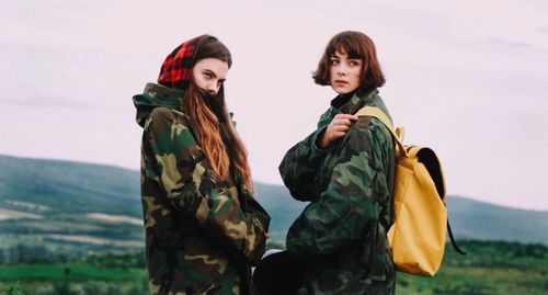 Female army soldiers standing against sky