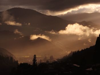 Silhouette of mountain against cloudy sky