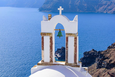 Building by sea against blue sky