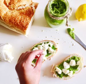 Cropped image of hand making sandwich on table