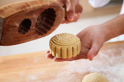 Midsection of woman preparing sweet baking food with dough at kitchen counter