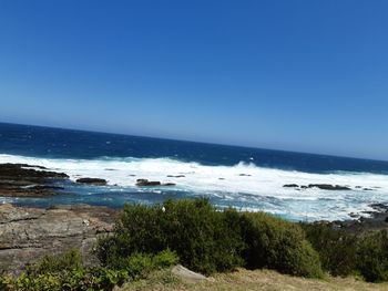 Scenic view of sea against clear blue sky