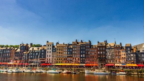 Boats in river against clear blue sky