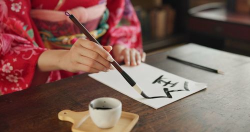 Midsection of woman working on table