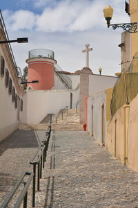 Steps amidst buildings against sky