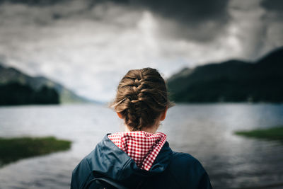 Rear view of boy on beach against sky