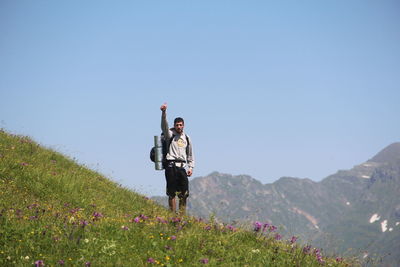 Full length of men on mountain against clear sky