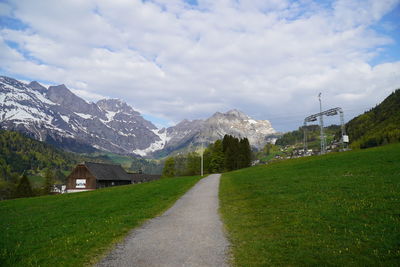 Road amidst green landscape against sky