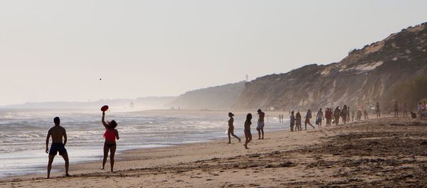 People on beach against sky