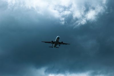 Low angle view of airplane flying against sky