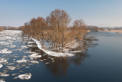 Scenic view of lake against sky during winter