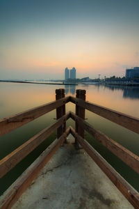 Pier over sea against sky during sunset