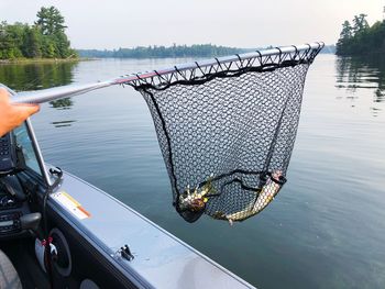 Hand holding fishing boat in lake