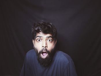 Portrait of young man against black background