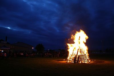 Bonfire on field against sky at night