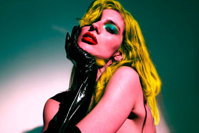 Portrait of young woman with face against blue background