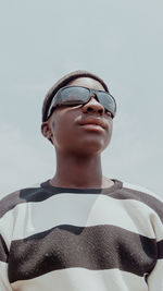 Portrait of young man wearing sunglasses against sky