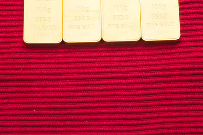 Directly above shot of gold bars on maroon textile