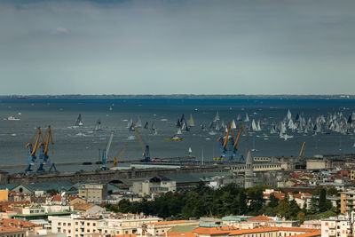 High angle view of buildings by sea against sky