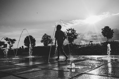 Man standing by swimming pool against sky