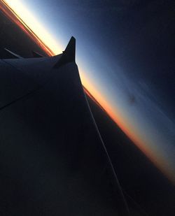 Low angle view of silhouette airplane against sky during sunset