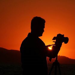 Silhouette of man standing at sunset