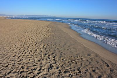 Scenic view of beach against clear blue sky