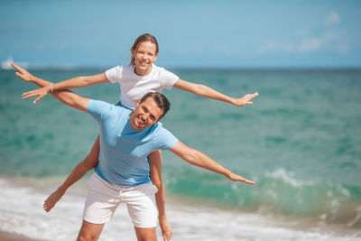 Full length of young woman jumping at beach