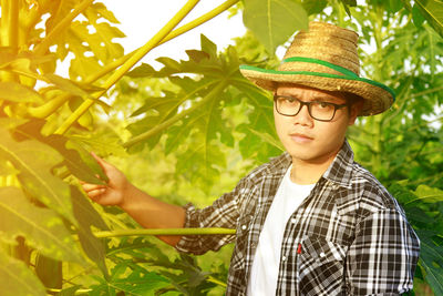 Portrait of young man with papaya plant