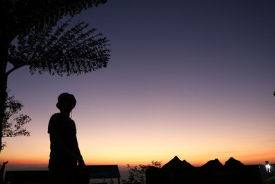 Silhouette man standing against orange sky