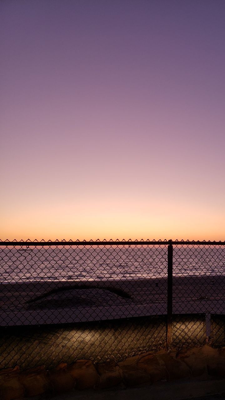 FENCE AGAINST CLEAR SKY AT SUNSET