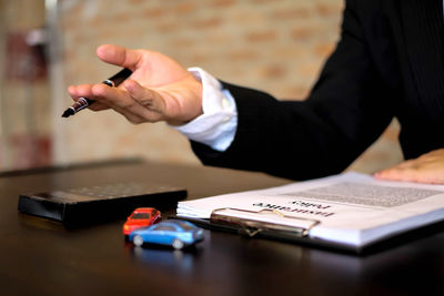 Midsection of man using mobile phone on table