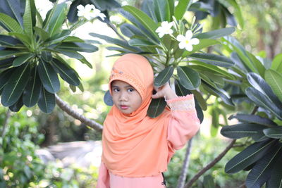 Portrait asian baby muslim wear orange dress and hijab  big eyes close up view, islamic lifestyle, 