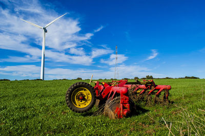 Traditional windmill on field against sky