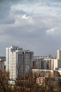 View of cityscape against cloudy sky