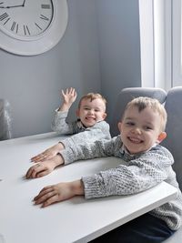 Portrait of smiling boys sitting at table