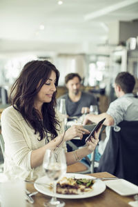 Woman sitting on table in restaurant