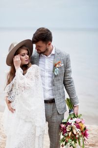 Bride and bridegroom standing at beach during wedding ceremony