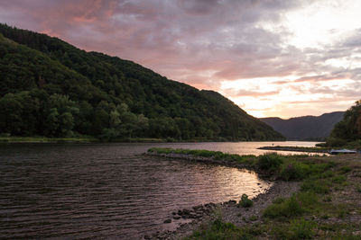 Scenic view of river against sky during sunset