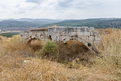 Old ruin on field against sky