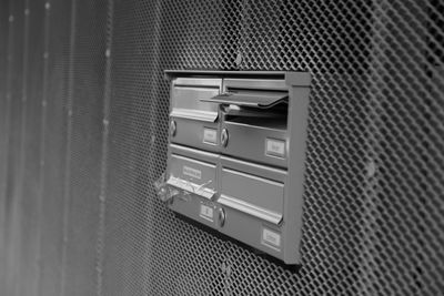 Mail in mailbox on metallic patterned wall at building