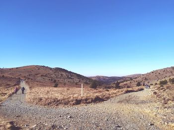 Scenic view of arid landscape against clear blue sky