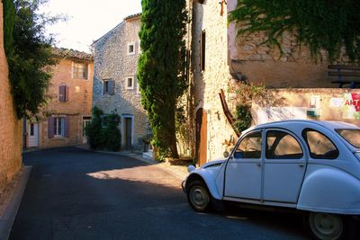 Car on street by buildings in city