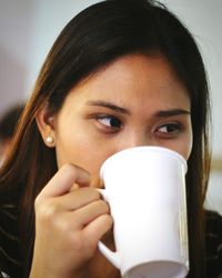 Close-up portrait of a woman drinking coffee cup