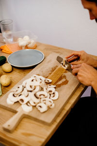 High angle view of man cutting mushroom on table