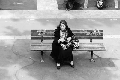 Full length of young woman sitting outdoors