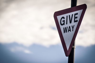 Low angle view of road sign against sky