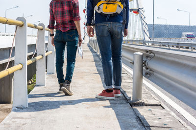 Rear view of people walking on bridge