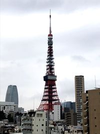 Buildings in city against cloudy sky