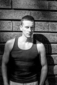 Portrait of young man standing against wall